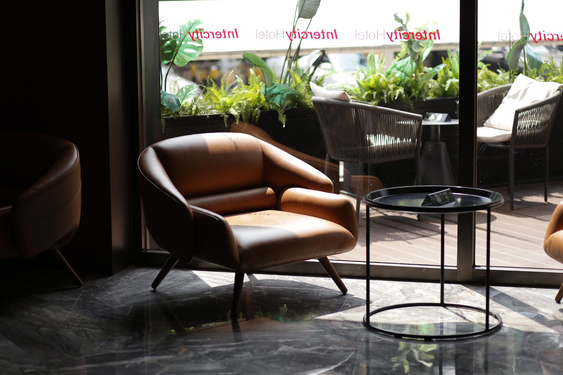 Hotel lobby lounge with low sofas, warm lamps and a reception desk